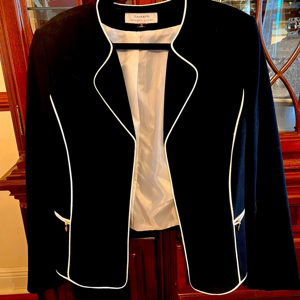 It’s a really cute jacket. It has white stiles that run down the black sleeves.